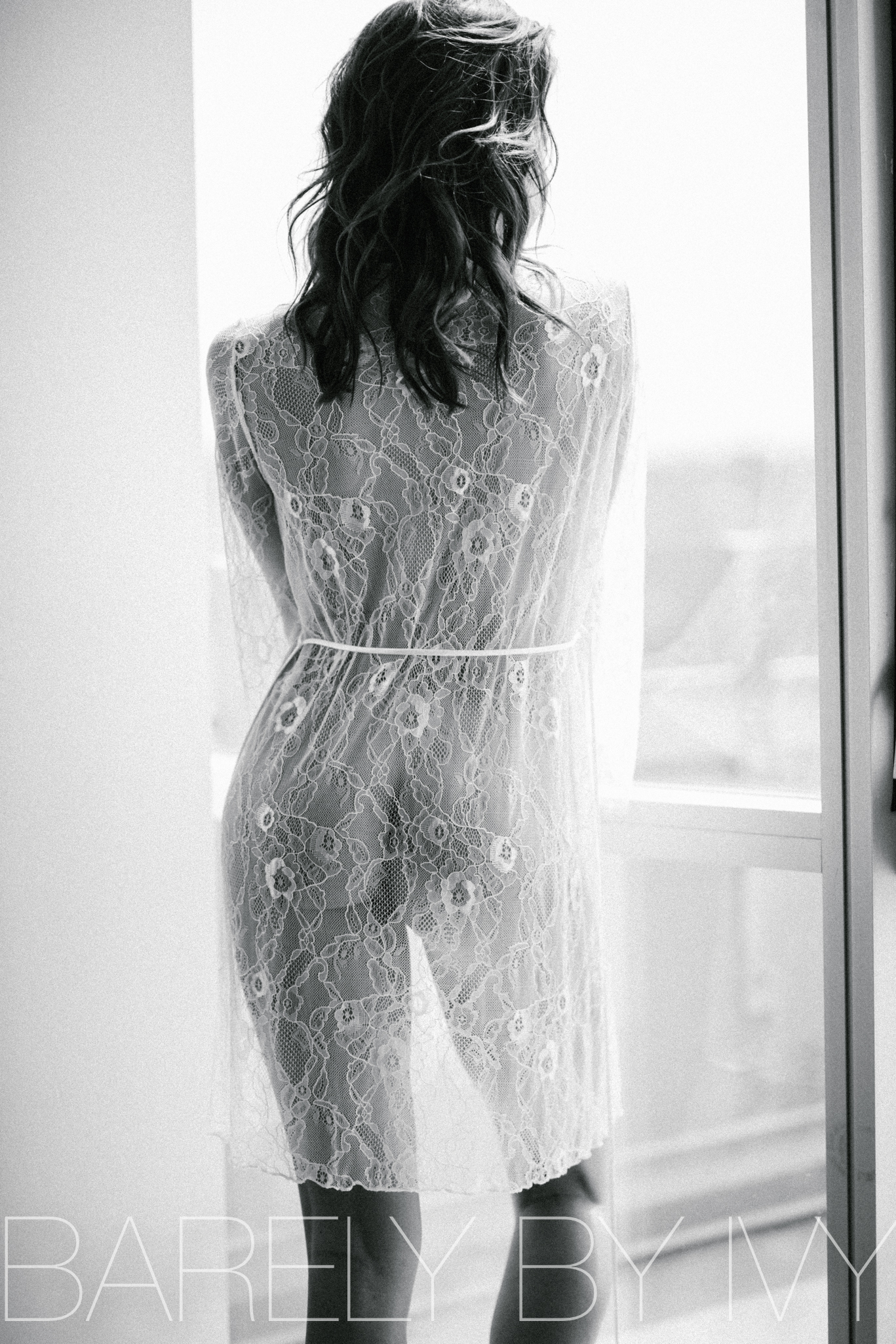 Backlit nude lingerie model in lace robe 
